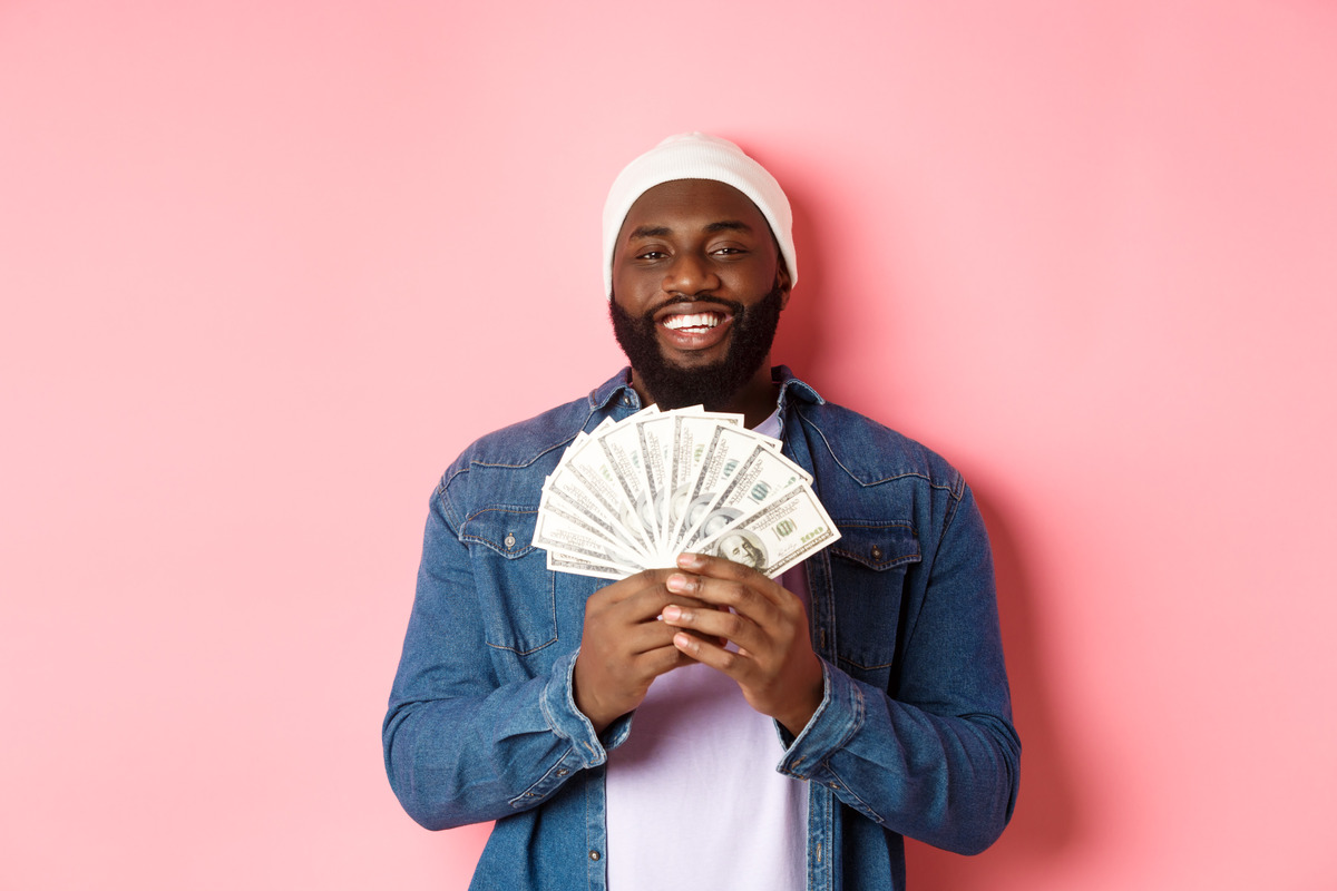 handsome bearded nigerian man showing the dollars he converted from naira